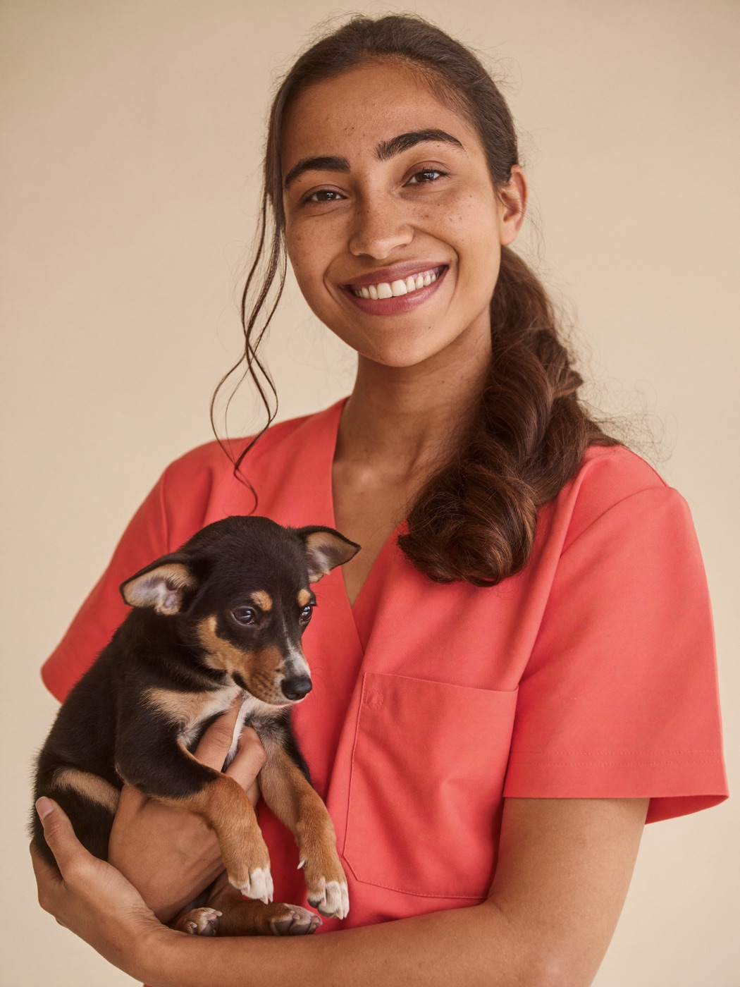 Sana Patel, lead veterinary technician at Brightpaw Veterinary, holding a sleepy puppy.